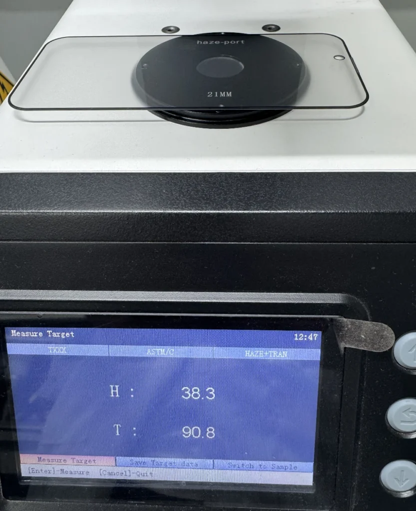 A haze meter optical test on a phone privacy screen protector, displaying a 38.3 haze level for data security and a 90.8% light transmittance