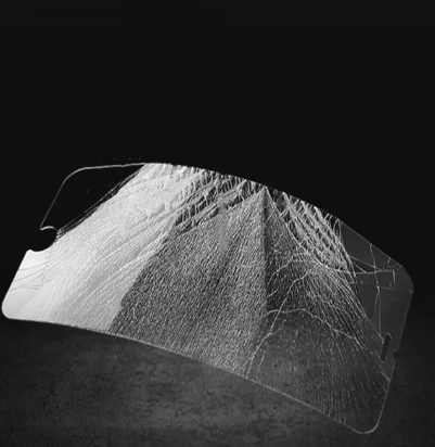 A severely shattered phone tempered glass screen protector showing a dense web of cracks from an extreme impact test.